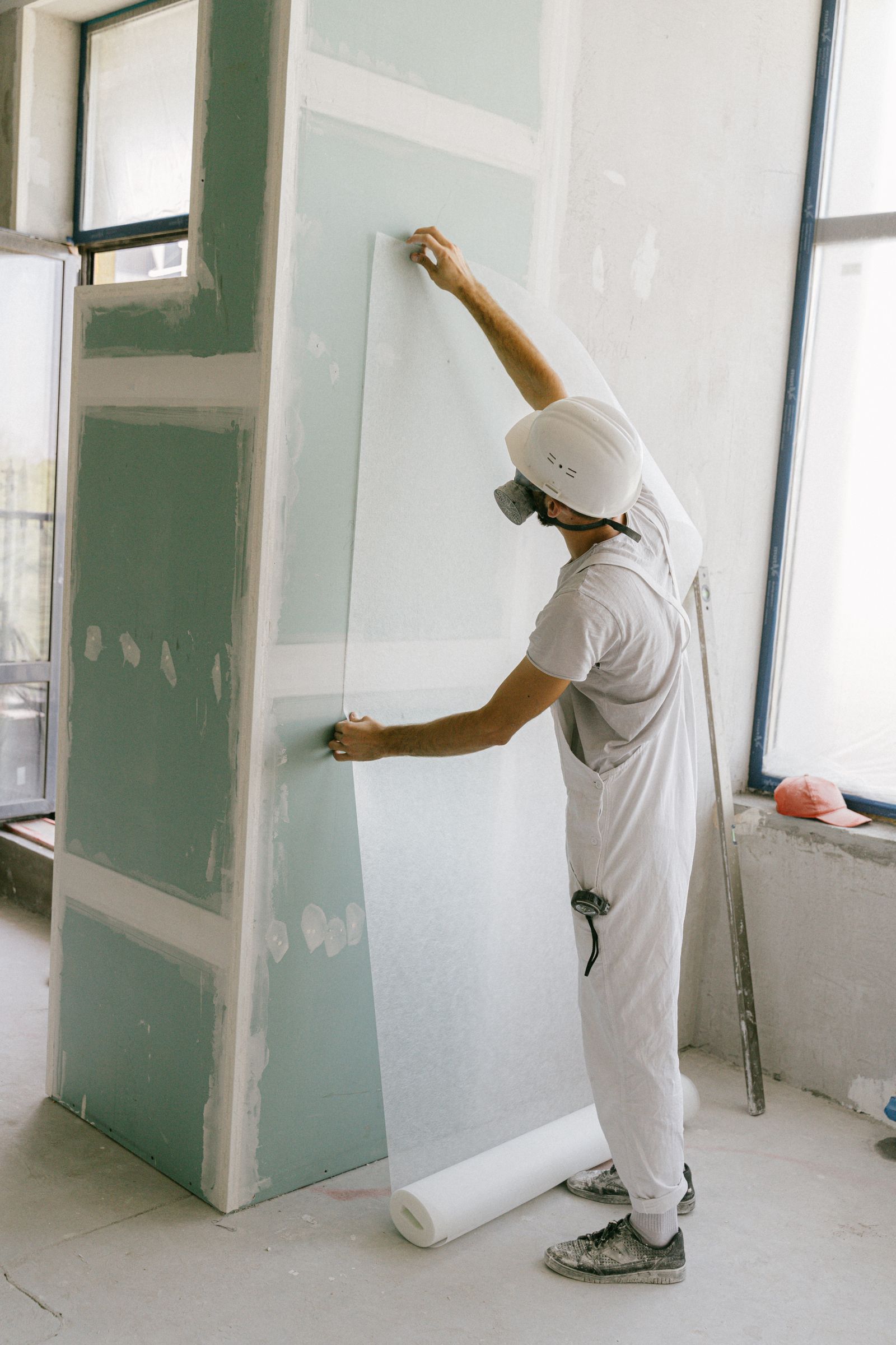 Installer smoothing a floral non-woven wallpaper